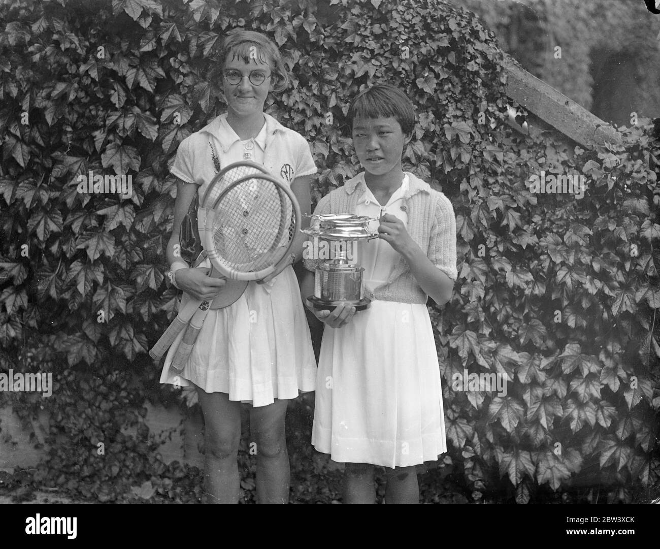 Gem Hoahing gana el título junior. Gem Hoaing, la chica China, venció a Miss R. Thomas 1 - 6 6 - 3 6 - 4 en la final de las chicas individuales del Campeonato Británico de Tenis Junior , Wimbledon . Espectáculos de fotos : Gem Hoaing y Miss R . Thomas después de su partido . 12 de septiembre de 1936 Foto de stock