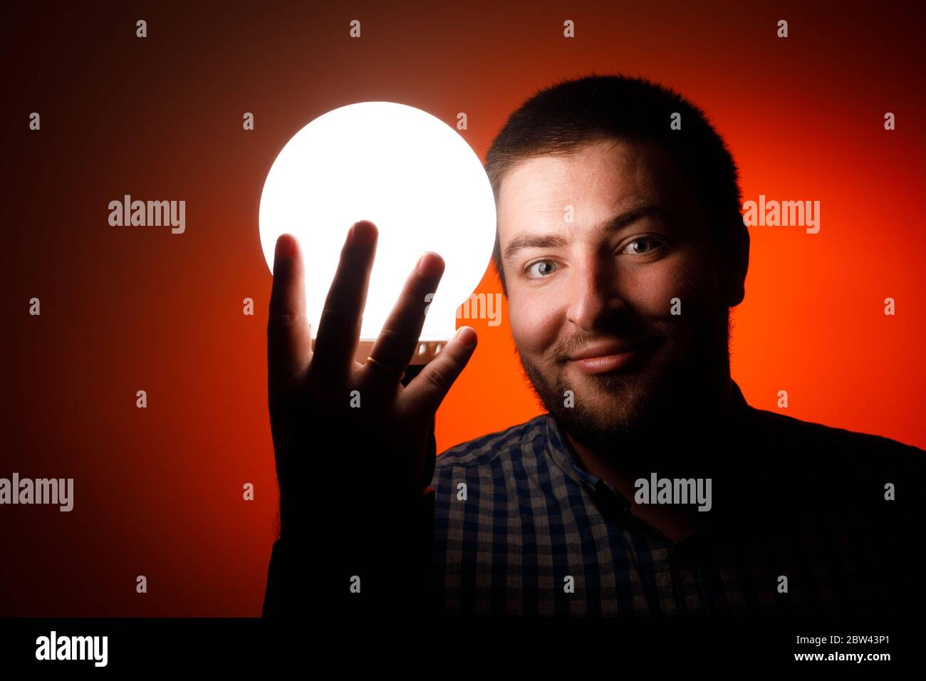 Hombre con una bola luminosa en sus manos. Foto de stock