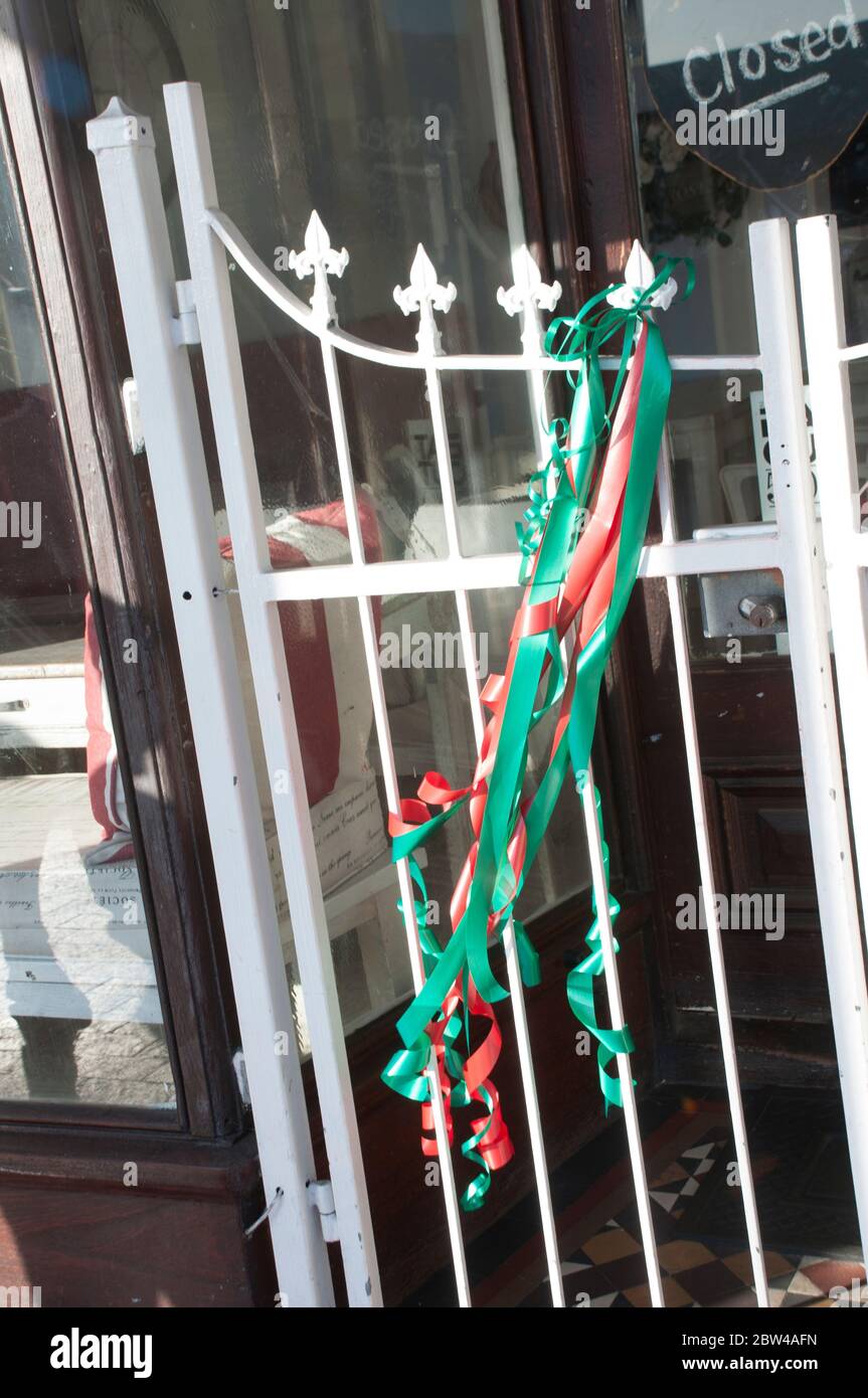 Puerta de hierro forjado decorada con cintas verdes y rojas Foto de stock
