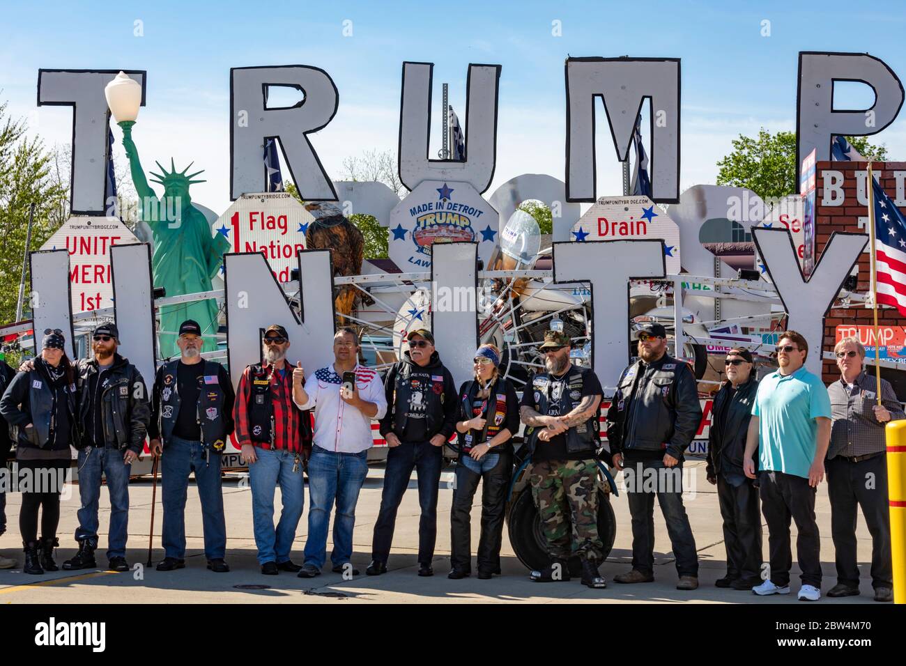 Lansing, Michigan - los ciclistas pro-Trump posan para una foto frente al Puente de Unidad de Trump. Se habían reunido fuera de una peluquería de al lado que desafió Foto de stock