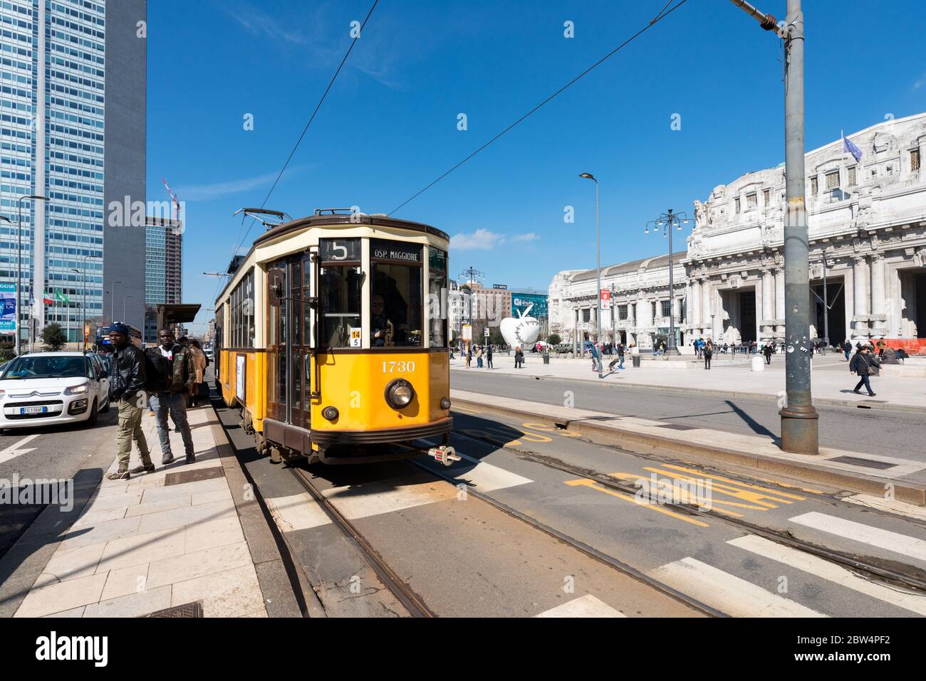 MILÁN, ITALIA - 16, MARZO, 2018: Imagen de gran angular del tranvía amarillo frente a la Estación Central de trenes de Milán, Italia Foto de stock