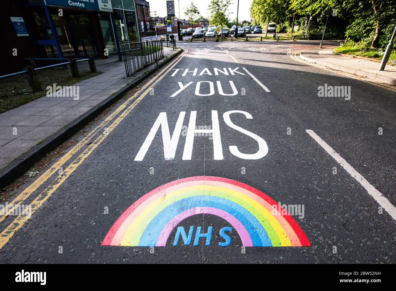 Nuevas marcas de carreteras pintadas Gracias NHS y un arco iris han sido pintados fuera de un centro médico en Manchester para agradecer a todo el personal de primera línea de NHS. Foto de stock