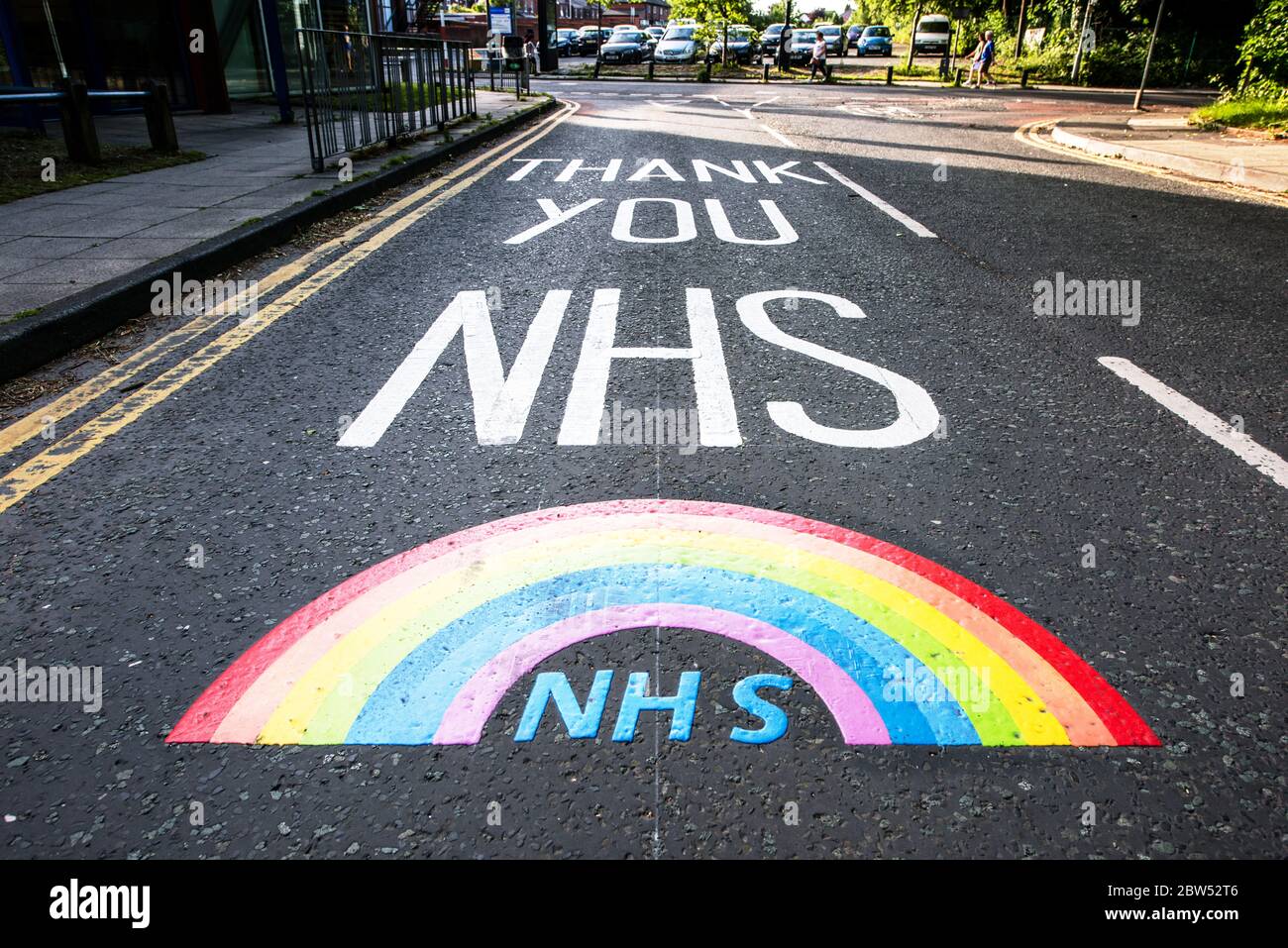 Nuevas marcas de carreteras pintadas Gracias NHS y un arco iris han sido pintados fuera de un centro médico en Manchester para agradecer a todo el personal de primera línea de NHS. Foto de stock