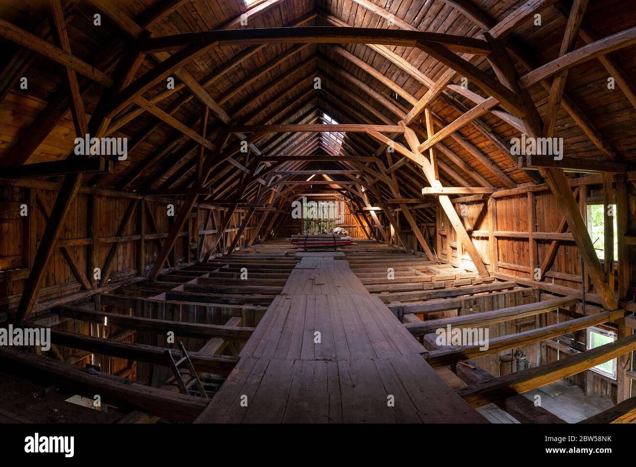 Interior de granero de madera viejo grande marco en Alemania durante la renovación, piso superior tiro de ángulo amplio Foto de stock