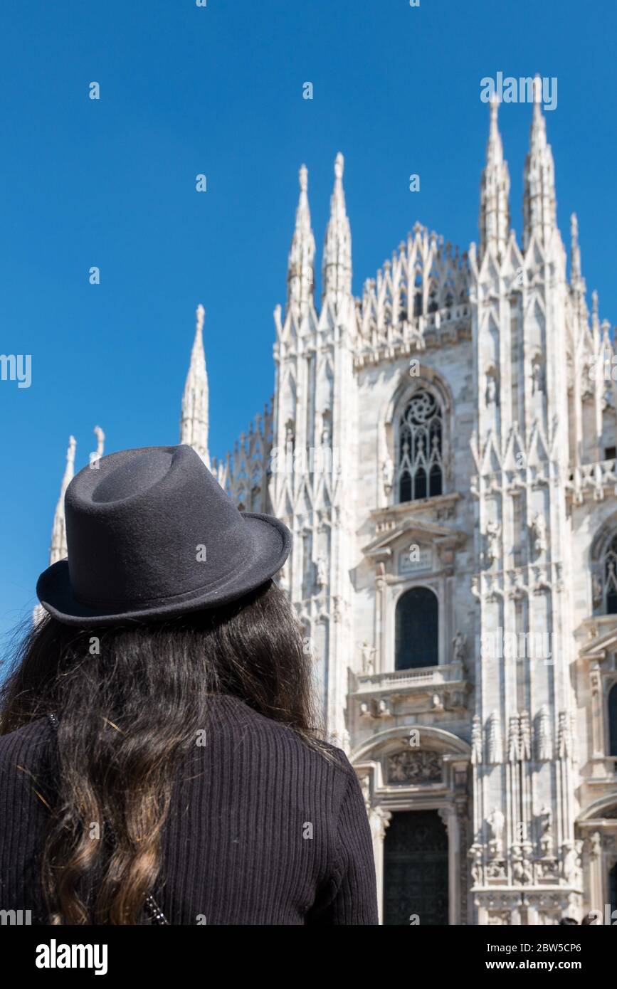 Imagen vertical de una joven morena mirando al Duomo di Milano en Milán, Italia Foto de stock
