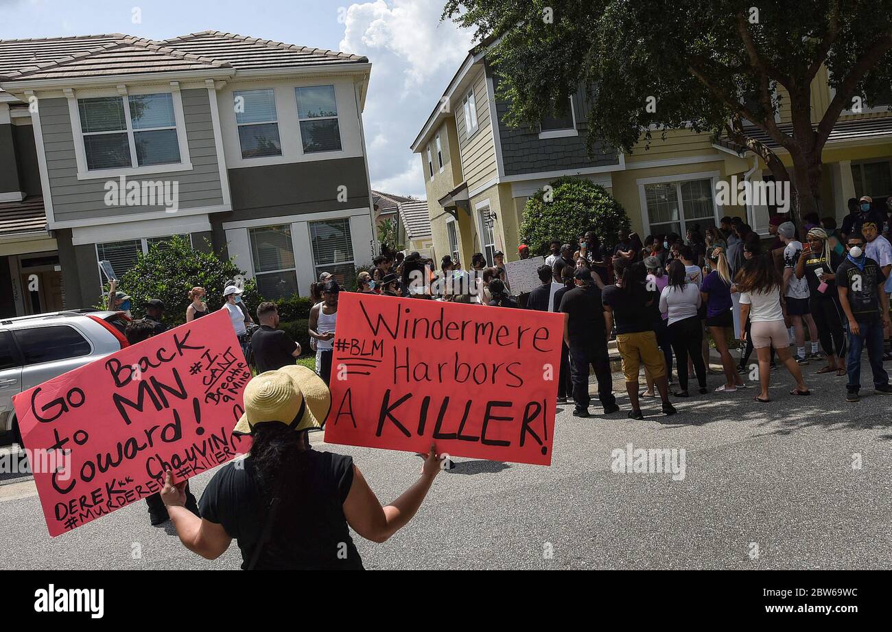 Windermere, Estados Unidos. 29 de mayo de 2020. Un manifestante sostiene pancartas durante una protesta en el exterior de una casa propiedad de Derek Chauvin, el oficial de policía de Minneapolis filmó una cinta de rodillas en el cuello de George Floyd antes de su muerte. El incidente ha provocado protestas en todo el país. Crédito: SOLA Images Limited/Alamy Live News Foto de stock