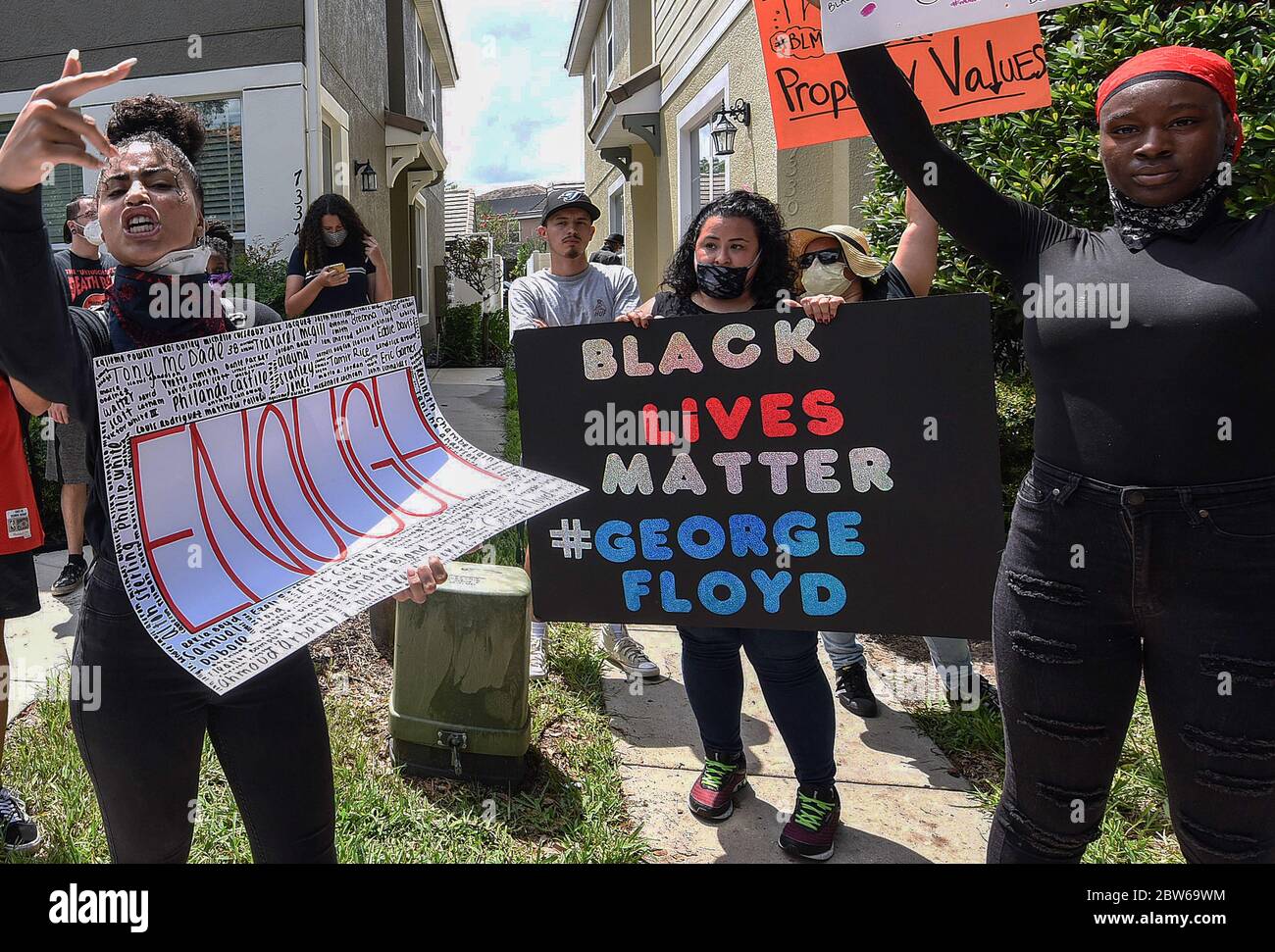 Windermere, Estados Unidos. 29 de mayo de 2020. El manifestante sostiene pancartas durante una protesta en el exterior de una casa propiedad de Derek Chauvin, el oficial de policía de Minneapolis filmó una cinta de rodillas en el cuello de George Floyd antes de su muerte. El incidente ha provocado protestas en todo el país. Crédito: SOLA Images Limited/Alamy Live News Foto de stock