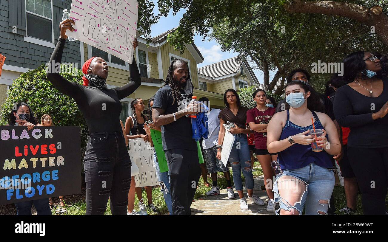 Windermere, Estados Unidos. 29 de mayo de 2020. Los manifestantes sostienen pancartas durante una protesta en el exterior de una casa propiedad de Derek Chauvin, el oficial de policía de Minneapolis filmó una cinta de rodillas en el cuello de George Floyd antes de su muerte. El incidente ha provocado protestas en todo el país. Crédito: SOLA Images Limited/Alamy Live News Foto de stock