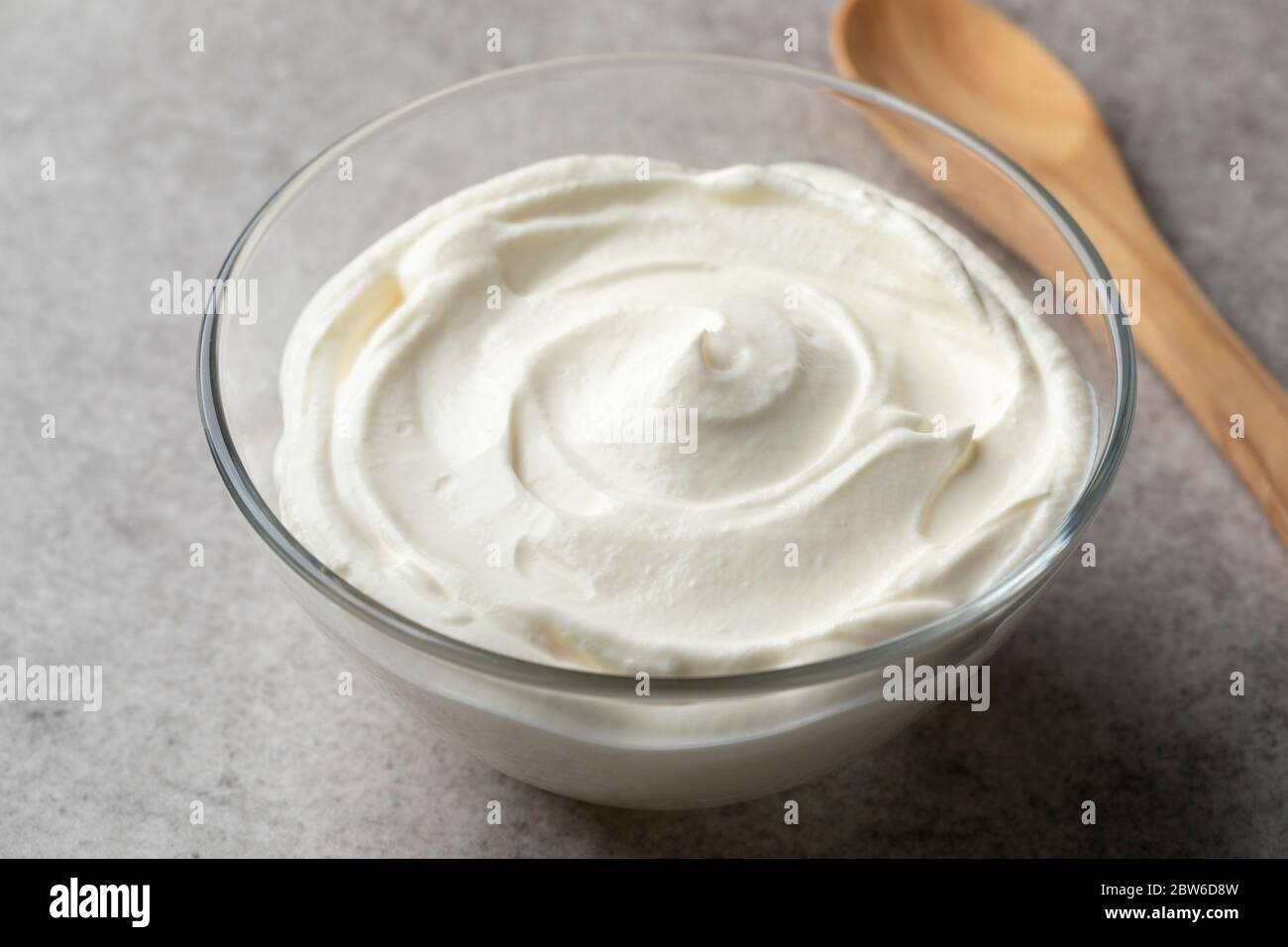 Crema fraiche lisa fresca en un tazón como ingrediente Foto de stock