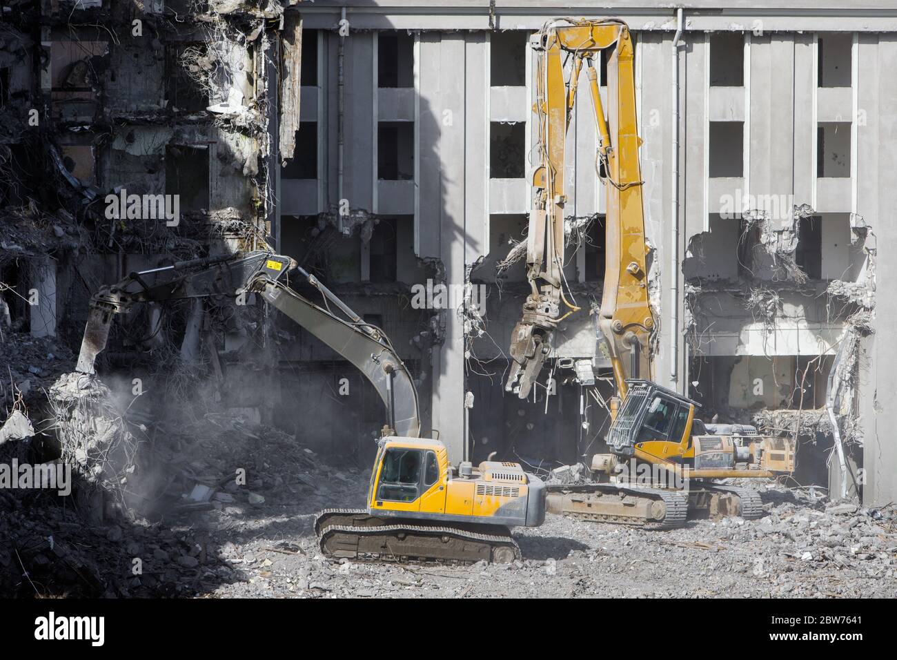 Construcción de la antigua demolición del hotel para la nueva construcción, usando dos excavadoras hidráulicas especiales. Demolición completa altamente mecanizada Foto de stock