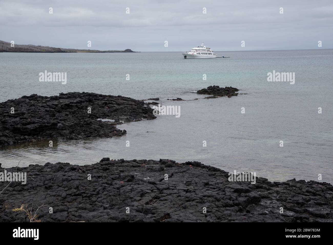 Coral 2 crucero en barco frente de la playa arenosa y rocosa de lava en la colina del Dragón en Santa Cruz en las Islas Galápagos. Foto de stock