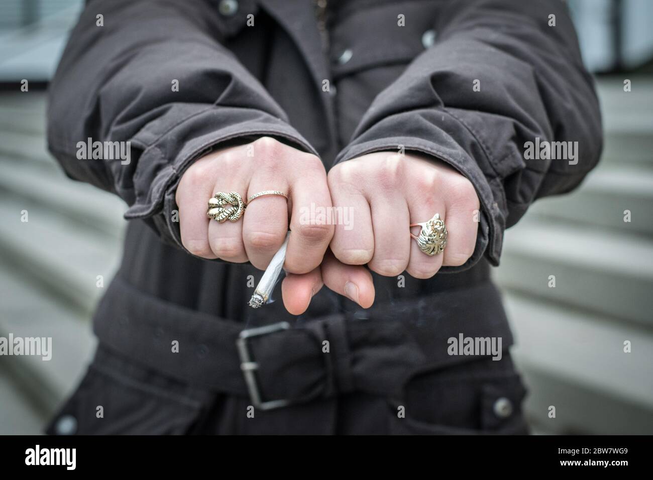 Jugendliche zeigt Fäuste mit Zigarette Foto de stock