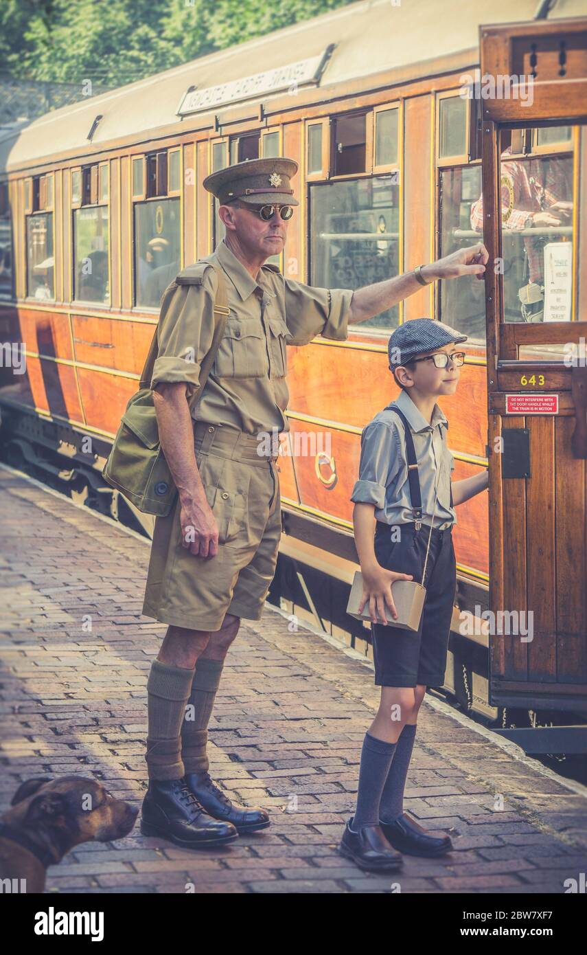 Severn Valley Railway, evento de verano de la Segunda Guerra Mundial de  1940, Reino Unido. 1940 hombre en uniforme y niño en aparatos ortopédicos y  gorra plana se están consiguiendo en el