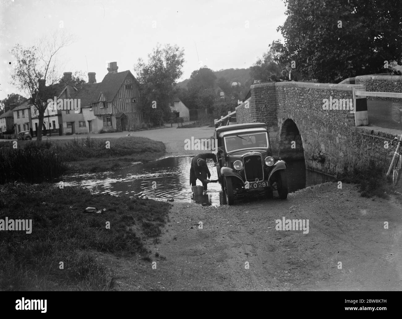 Los lugareños lavan su vehículo en el río en Eynsford. 1935 . Foto de stock