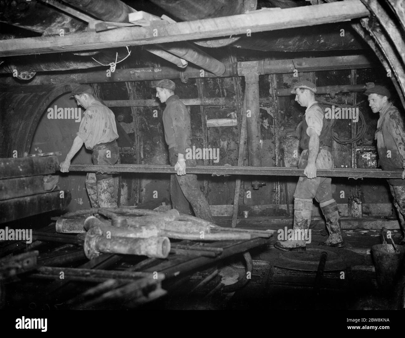 Los hombres del túnel de Dartford llevan parte del marco metálico a su posición. 1938 Foto de stock