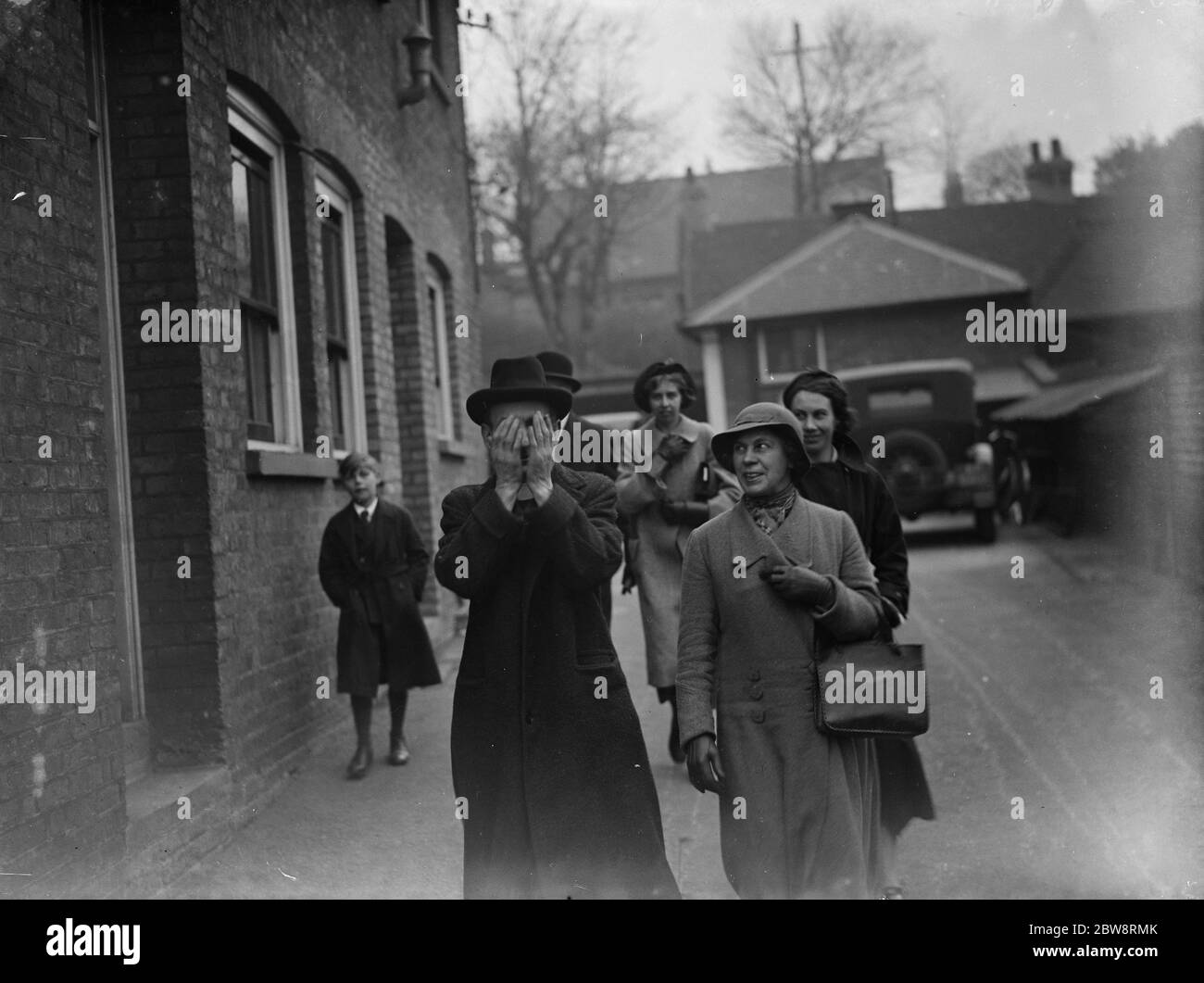 El Vicario de Greenhithe esconde su rostro cuando deja la corte, acusado de agredir a un niño. 13 de diciembre de 1935 Foto de stock