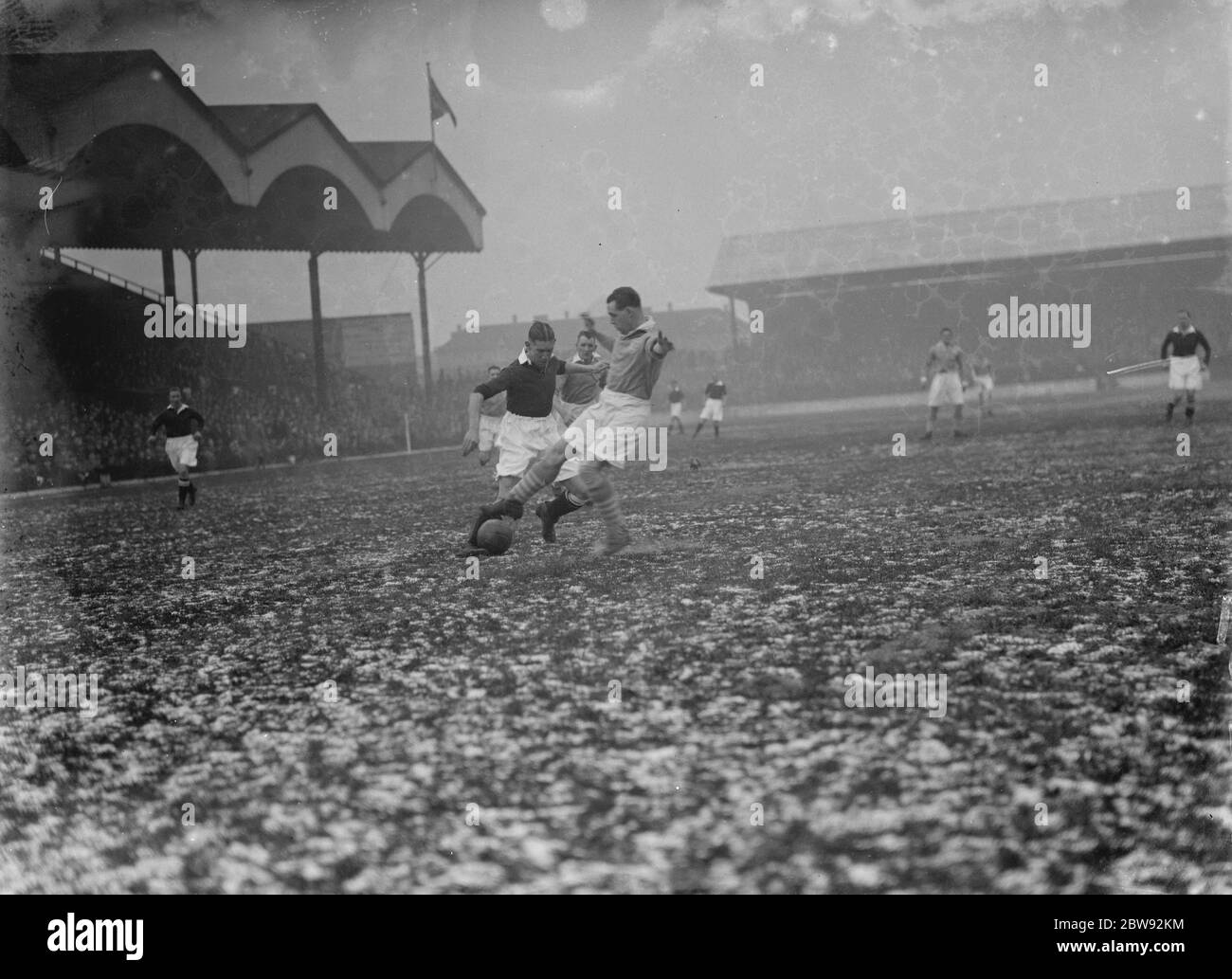 Acción en el campo de fútbol . Dos jugadores compiten por la pelota. 1939 Foto de stock