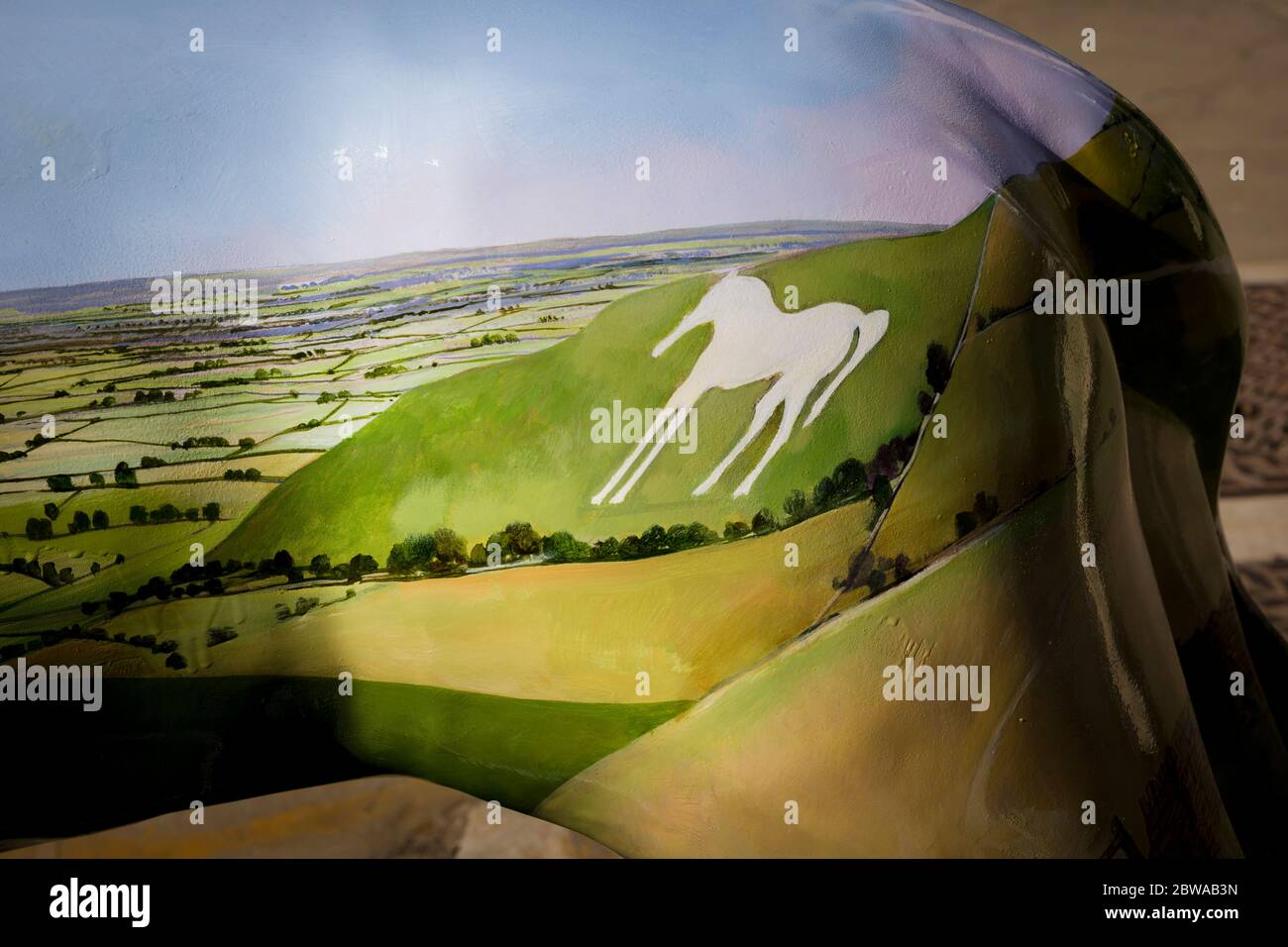 Una zona del paisaje de Wiltshire, incluyendo un característico caballo blanco cortado de chalkland bajs, pintado en el flanco de un león ornamental utilizado para el interés urbano Foto de stock