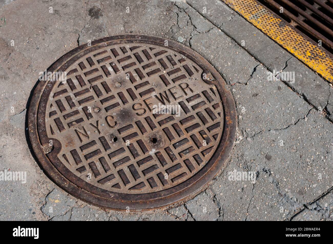 Cubierta metálica de alcantarilla marcó a NYC Sewer en una acera en Brooklyn, Nueva York, Nueva York, Estados Unidos. Infraestructura. Cobertura de alcantarilla. Foto de stock