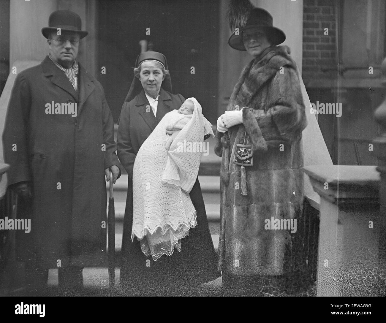 Sir Claud y Lady Severn con su hijo después del bautizo de este último en St Cuthbert's , Philbeach Gardens . 13 de diciembre de 1926 Foto de stock