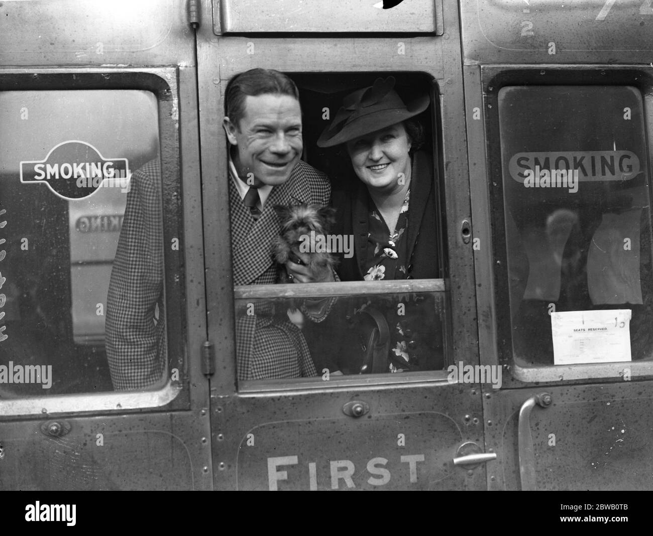 En la estación de Waterloo a su regreso a los Estados Unidos , la estrella del cine americano , Joe E Brown , su esposa y su perro pequeño. 1936 Foto de stock