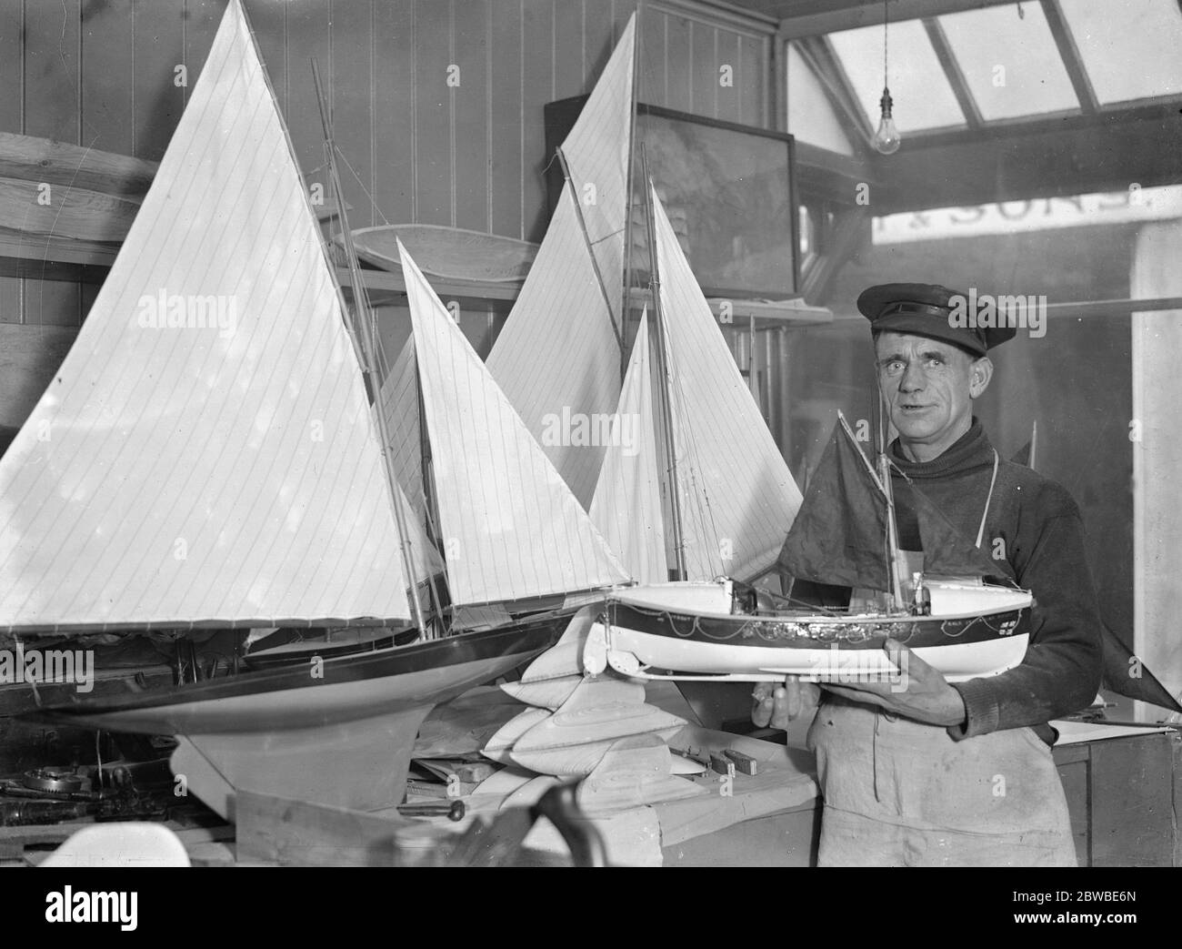 En el pintoresco barrio de pesca de Hastings trabaja el médico de los barcos, quizás el único de su tipo. Es ingeniero de las ciudades "lancha motora" del Sr. W R Hilder. No solo repara modelos de yates enviados desde las grandes tiendas de Londres, sino que recieve embarcaciones de todo el mundo para reparar y remontar. El Sr. Hilder en el trabajo y también con una réplica exacta del motor de la lancha salvavidas ' Cyril y Lilian obispo ' 26 de noviembre de 1931 Foto de stock