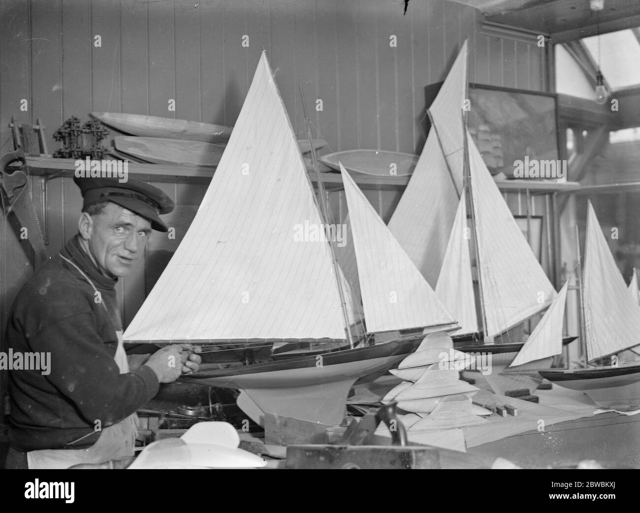 En el pintoresco barrio de pesca de Hastings trabaja el médico de los barcos, quizás el único de su tipo. Es ingeniero de las ciudades "lancha motora" del Sr. W R Hilder. No solo repara modelos de yates enviados desde las grandes tiendas de Londres, sino que recieve embarcaciones de todo el mundo para reparar y remontar. El Sr. Hilder en el trabajo y también con una réplica exacta del motor de la lancha salvavidas ' Cyril y Lilian obispo ' 26 de noviembre de 1931 Foto de stock