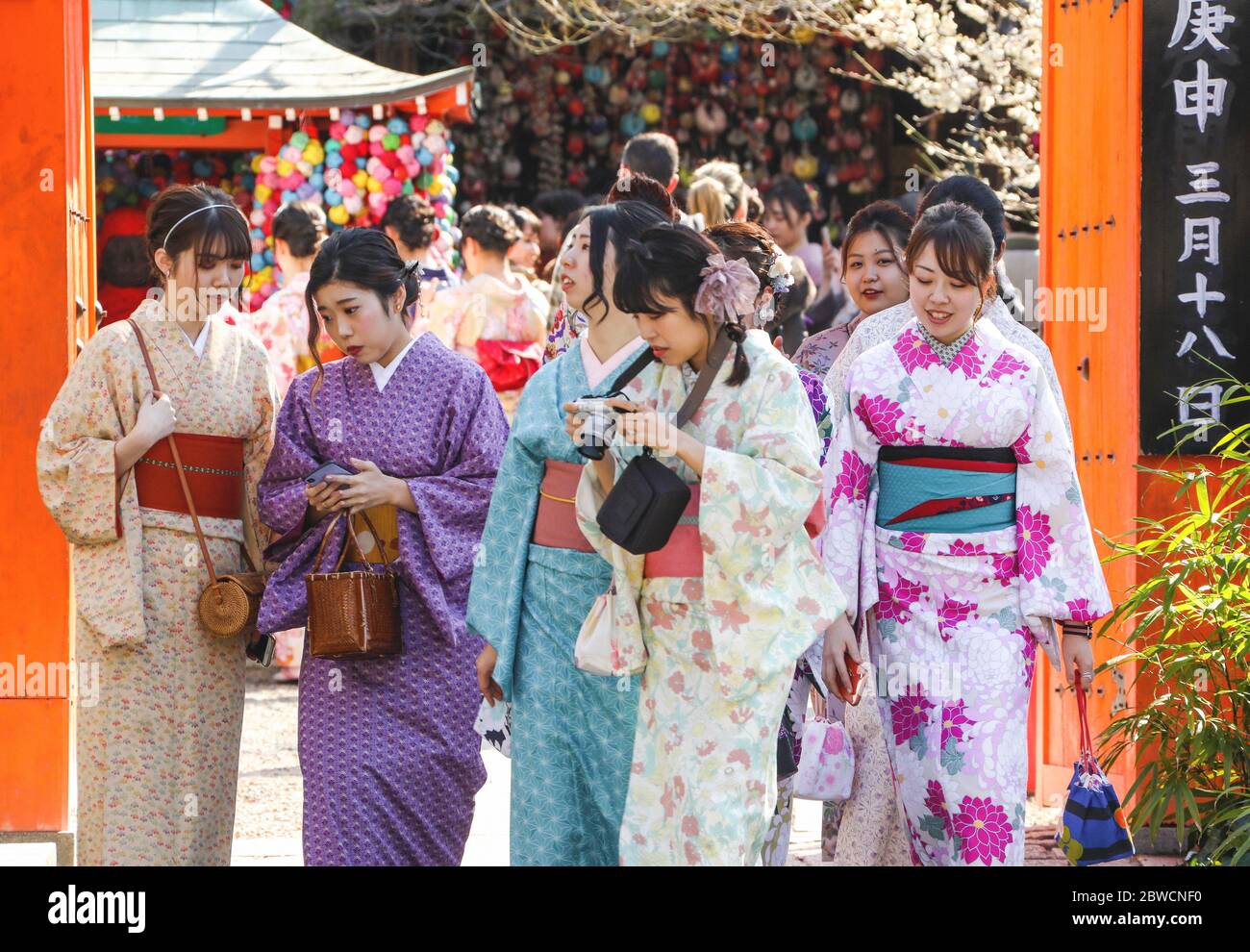 Grupo de jóvenes japoneses vestidos con trajes kimono tradicionales caminando por la calle en Kioto, Japón Foto de stock