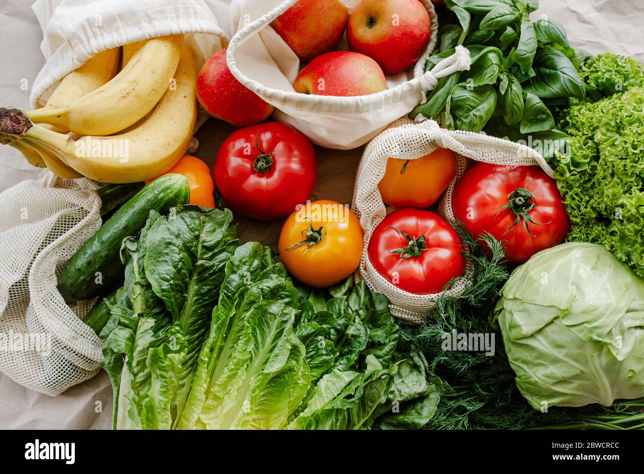 Verduras frescas y frutas en bolsas reutilizables de algodón ecológico en la mesa en la cocina. Vida sostenible Foto de stock