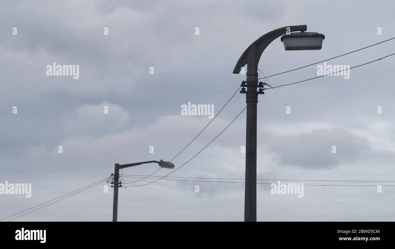 https www alamy es viejas lamparas de calle contra el cielo gris con cables de lineas de energia el primer poste de la lampara es un tipo de hormigon de decadas de antiguedad con lampara sox glasgow escocia reino unido image359863412 html