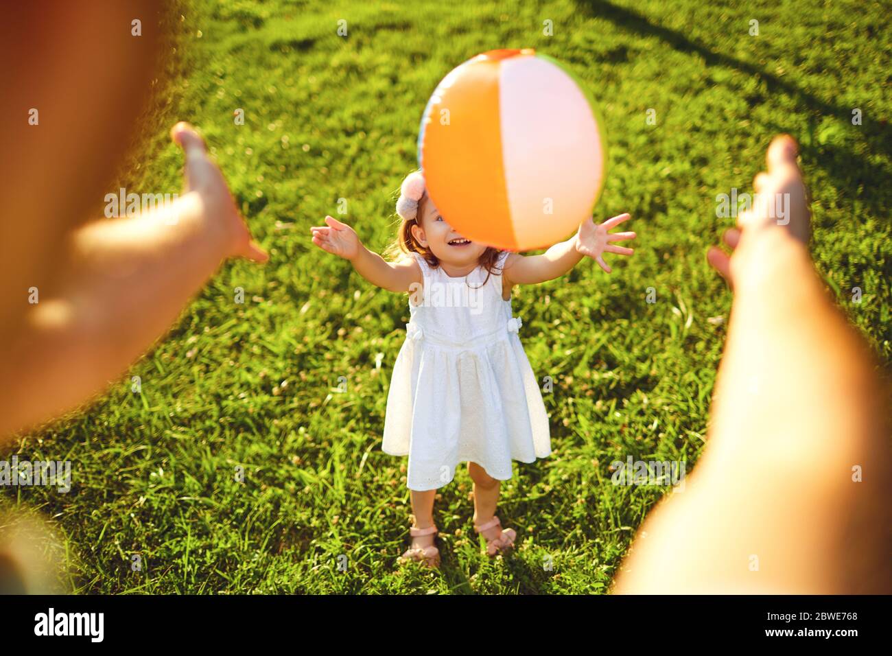 Feliz familia caminando en la hierba en el parque de verano. Madre padre y niños jugando en la naturaleza. Día De La Protección De Los Niños. Foto de stock