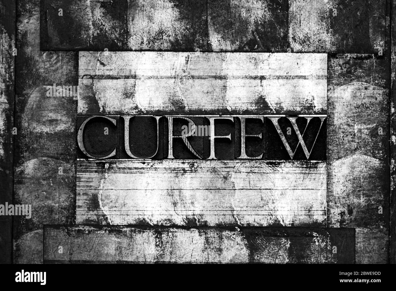 Foto de verdaderas letras de composición auténtica que forman el toque de queda texto sobre la cosecha textura monocromo fondo gris plata Foto de stock
