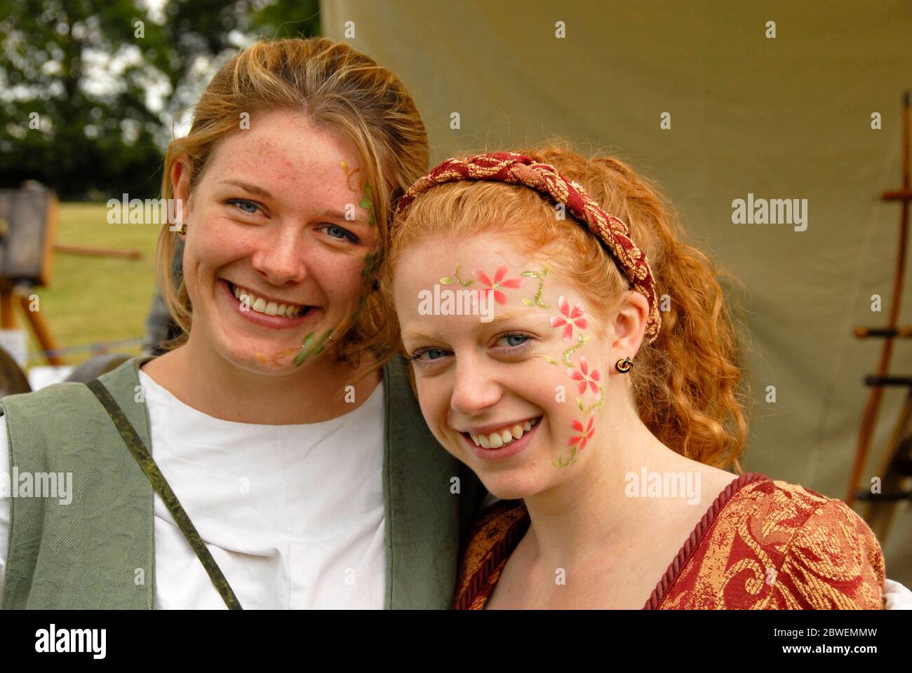 Dos atractivas damas jóvenes con traje de día de olden en la feria de verano. Inglaterra Foto de stock