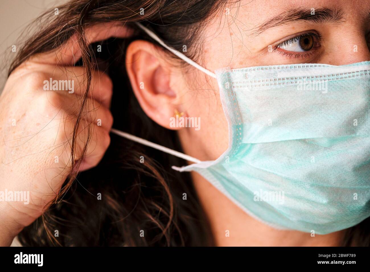 Mujer que usa una máscara protectora para prevenir el COVID-19 y otras infecciones. Foto de stock