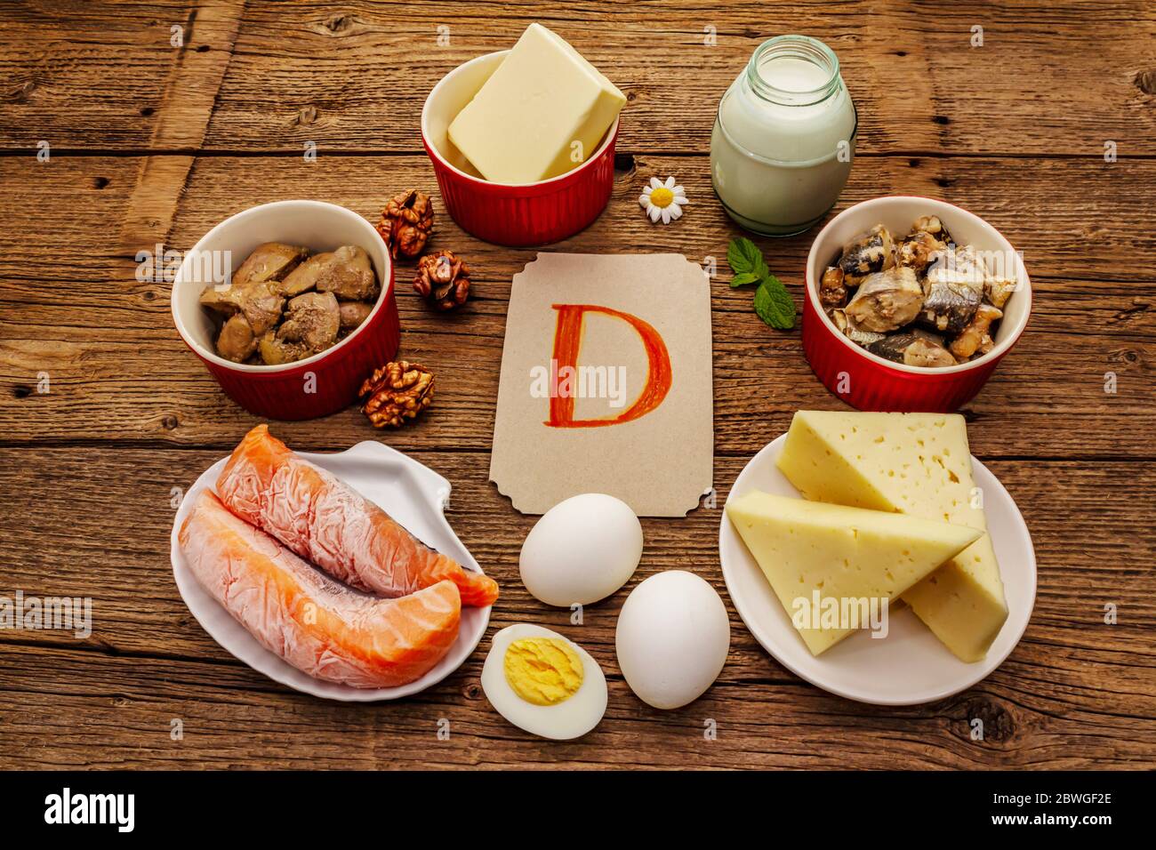 Alimentos que contienen vitamina D. Queso, huevos, mantequilla, nueces,  leche, sardina, salmón, hígado. Viejas tablas de madera de fondo Fotografía  de stock - Alamy