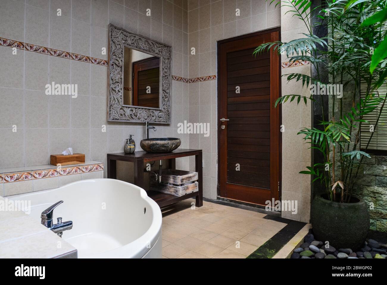 Baño con lavabo de piedra, espejo y toallas en estilo tradicional balinés  en la casa, Indonesia Fotografía de stock - Alamy