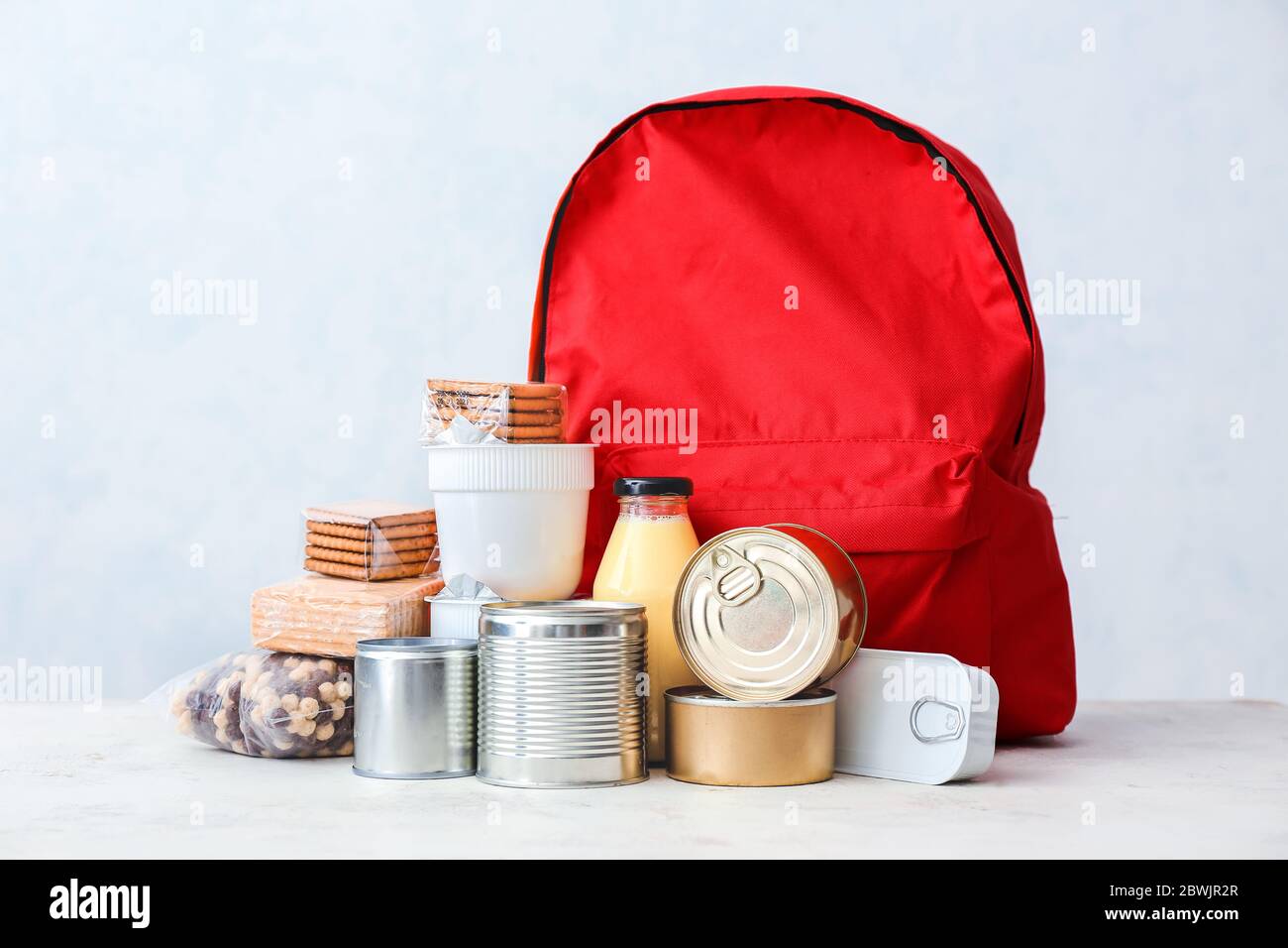 Bolsa escolar con diferentes productos sobre fondo claro. Concepto de  programa de comida de mochila Fotografía de stock - Alamy
