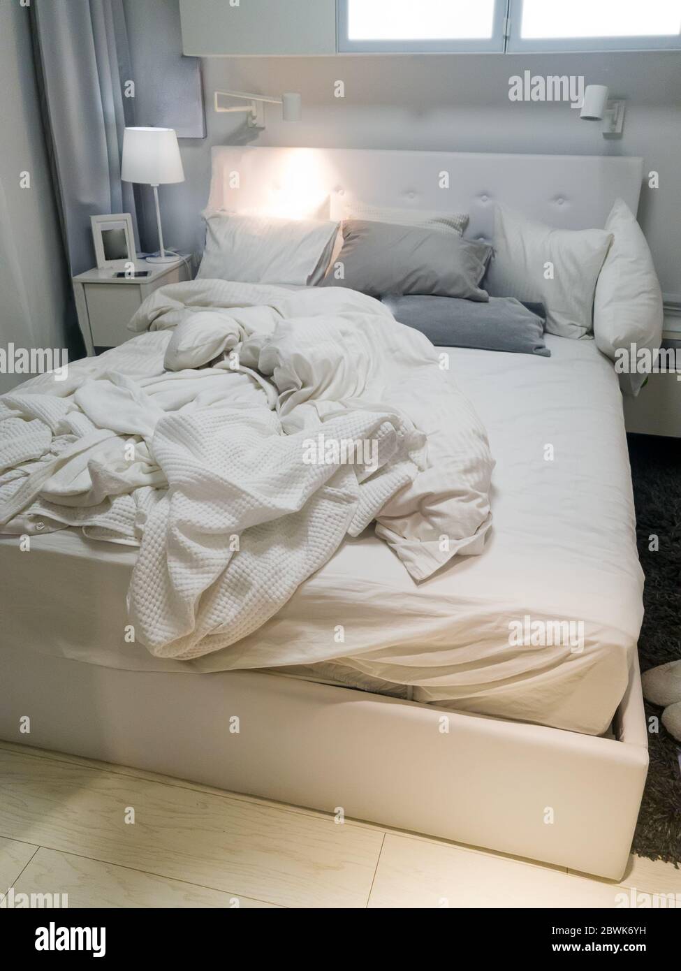 Sábanas blancas y almohada en el fondo de la habitación, cama desordenada  por la noche Fotografía de stock - Alamy