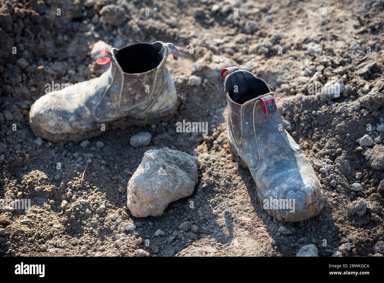 Profundidad de campo de una imagen de un constructor botas cubiertas de acero en el barro Foto de stock