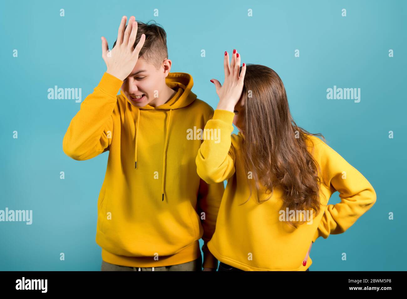 facepalm de hermano y hermana en sudaderas amarillas Fotografía de stock -  Alamy