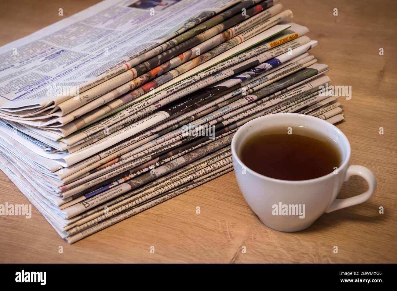 enfoque selectivo de la taza de té apilando periódicos doblados colocar sobre mesa de madera Foto de stock