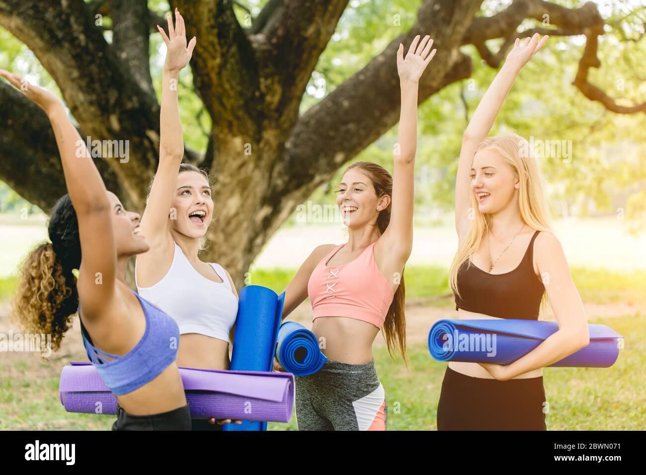 Clase de yoga al aire libre, Grupo de jóvenes mujeres sanas adolescentes feliz saludo reunión juntos para el ejercicio. Foto de stock