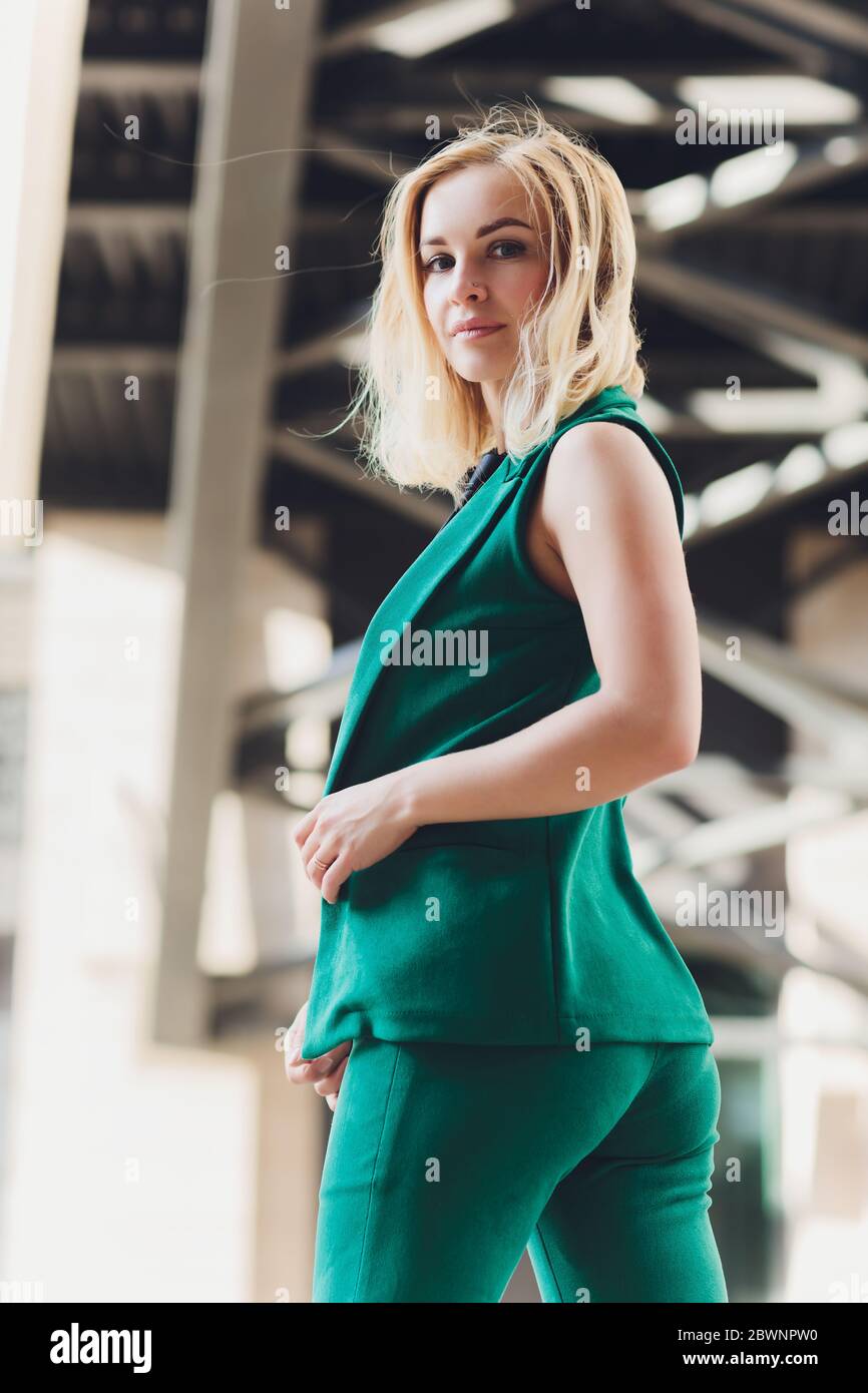 Mujer joven y bonita con chaqueta verde brillante y pantalones caminando  por la calle de la ciudad. Moda informal, modelo de tamaño plus, estilo  urbano, estilo otoño Fotografía de stock - Alamy