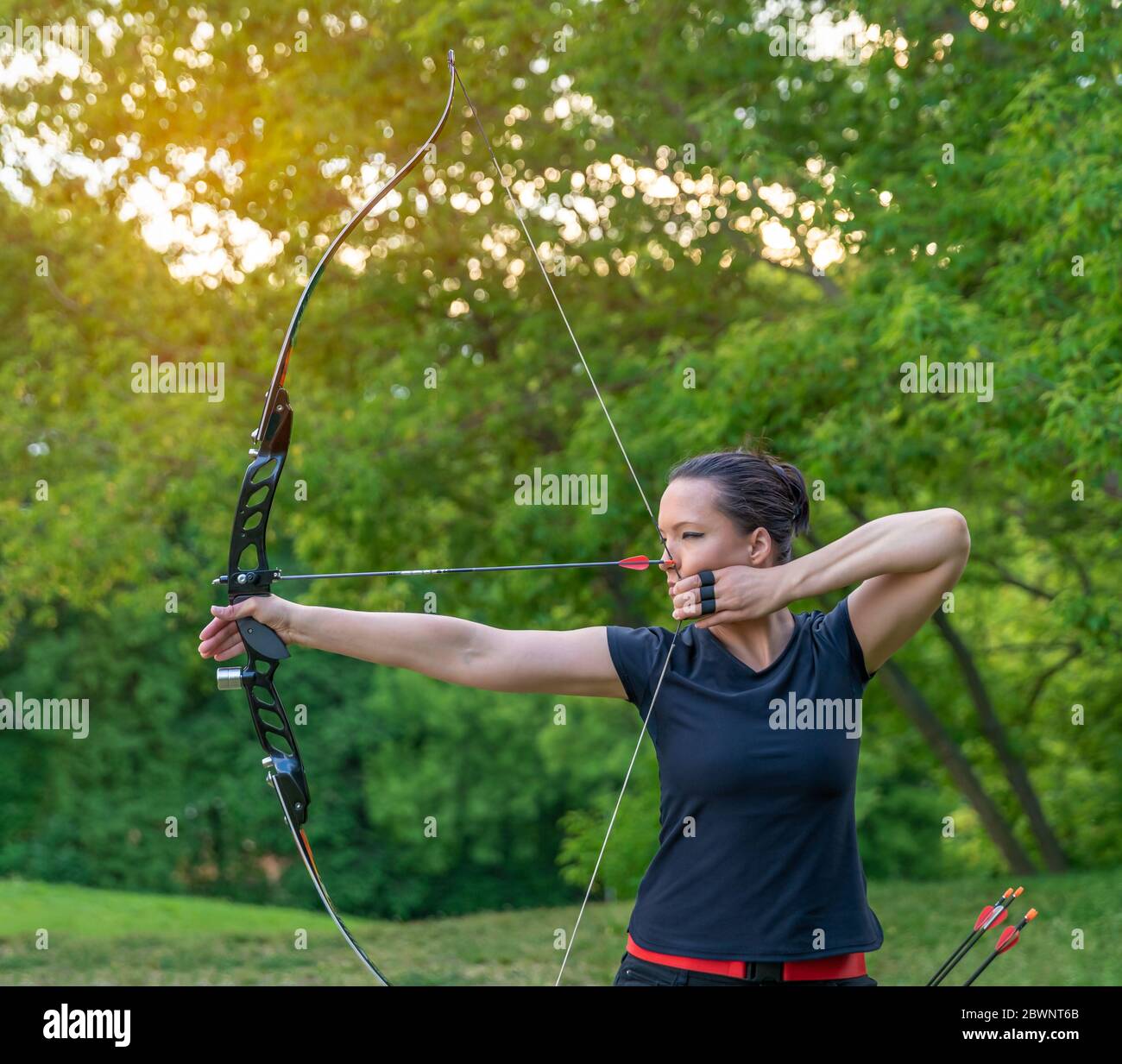 mujer deportiva atractiva en tiro con arco, flechas y arco en acción  Fotografía de stock - Alamy