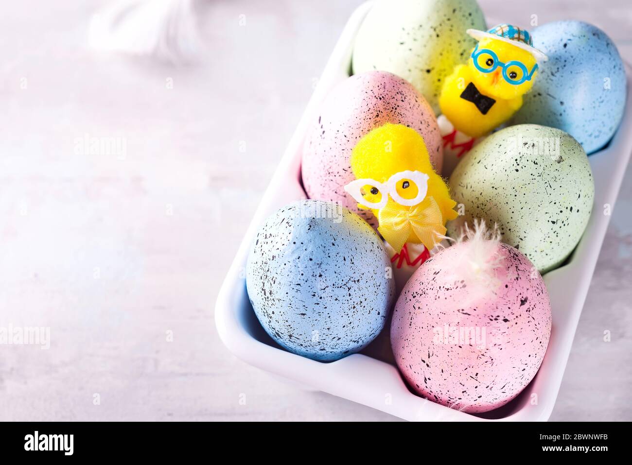Huevos de pascua de colores orgánicos en caja decorativa de porcelana sobre blanco. Vacaciones concepto de Pascua . Foto de stock