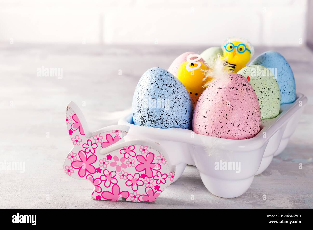 Huevos de pascua de colores orgánicos con conejito de cutie en caja decorativa de porcelana sobre blanco. Vacaciones concepto de Pascua . Foto de stock
