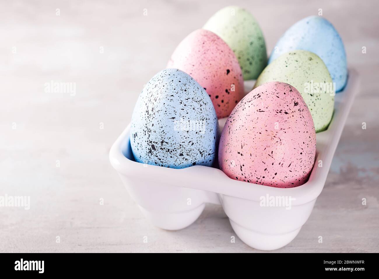 Huevos de pascua de colores orgánicos en caja decorativa de porcelana sobre blanco. Vacaciones concepto de Pascua . Foto de stock