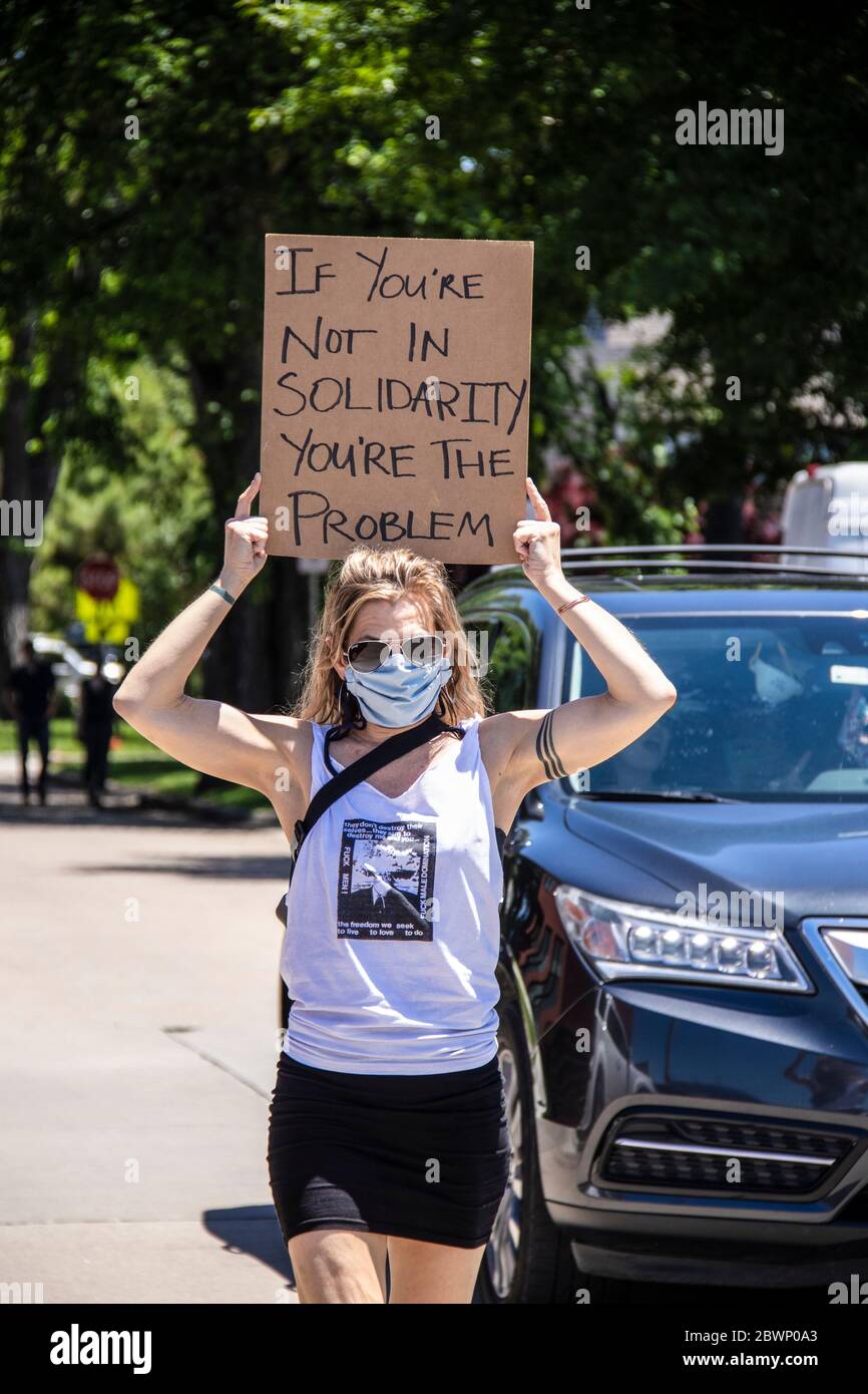 05-30-2020 Tulsa USA - Mujer con mini-falda y F hombres camiseta camina con el signo sostenido sobre su cabeza leyendo Si no estás en solidaridad eres el proble Foto de stock