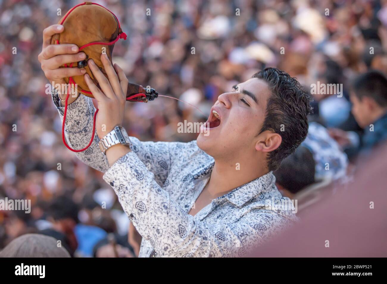 Hombre bebiendo vino de la bolsa de cuero español Foto de stock