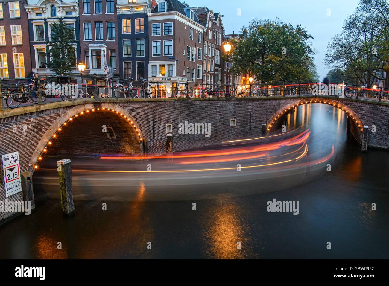Reflexiones de la iluminación de puentes en canales al atardecer, Amsterdam, Holanda del Norte, países Bajos. Foto de stock